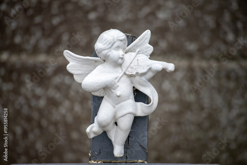 Fotografi White cherub angel playing violin sculpture