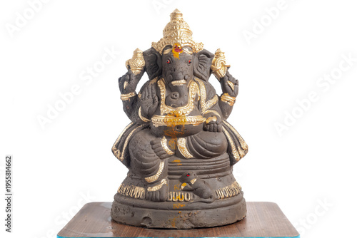 Clay Ganesha idol decorated in gold color for home decoration and spiritual worship.