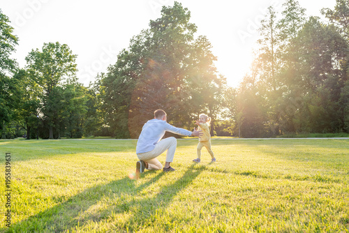 Parenting outdoors. Happy father and toddler girl in park.