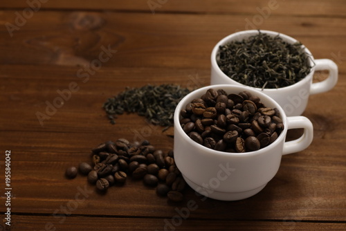 Cups with coffee and tea on wooden table