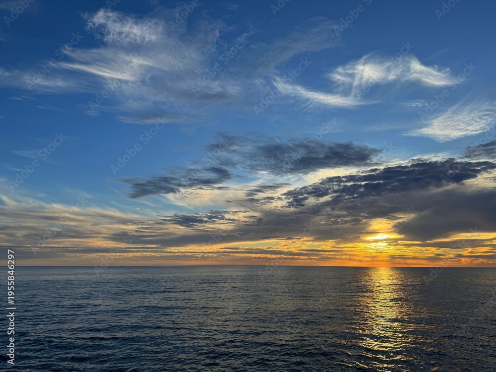 Fototapeta premium Calm ocean and sunset sky clouds.