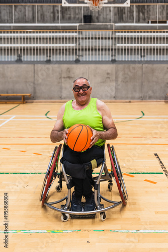 Картината върху платно Smiling man with disability holding a basketball, participating in para sports f
