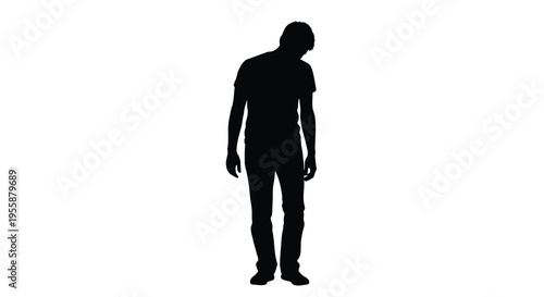A lone man stands with his head bowed in a stark silhouette
