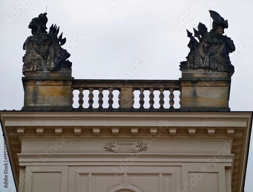 Fotografi Urban rooftop range displaying weathered stone sculptures with atmospheric sky c