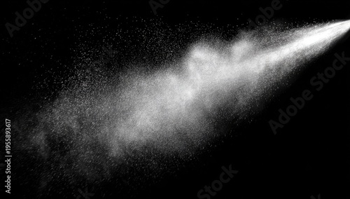 Fine mist of liquid spray suspended against a black background, bright light