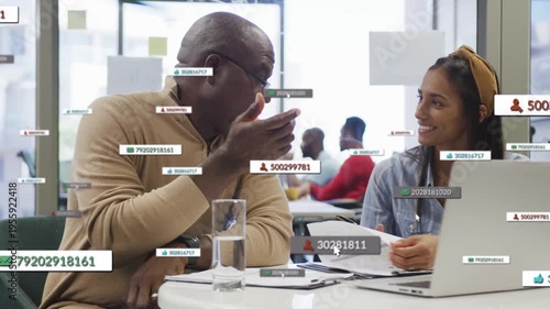 Mentor pointing papers in education hub, initiating digital overlays while mentee taking notes