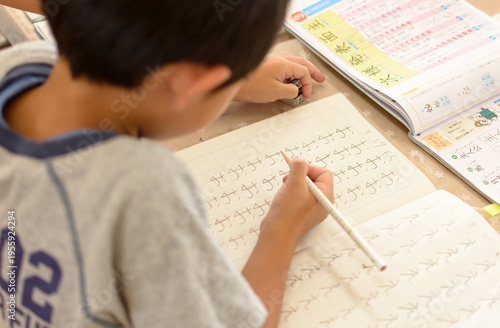 家庭学習で漢字を書く児童 教育イメージ