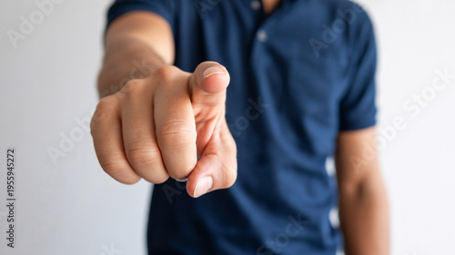 A man points directly at the camera with his index finger extended.
