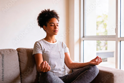 Mulher relaxando em meditação no sofá com luz natural e ambiente acolhedor