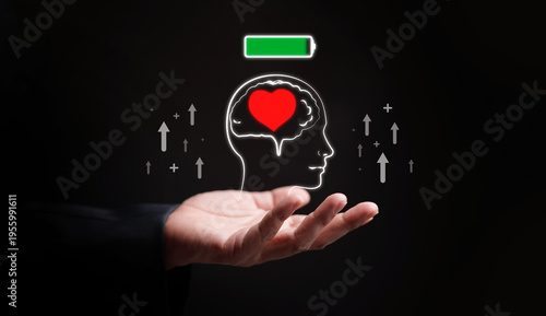 Human head with glowing heart inside brain and full energy battery icon above hand. Mental health, healthy attitude and mindset, emotional intelligence, wellbeing, recharge, growth, digital healthcare