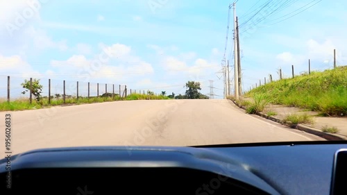 POV driving on an open road with clear sky and roadside infrastructure. Ideal for transportation, travel, mobility, and connectivity concepts.