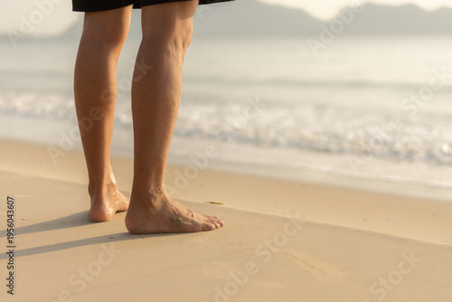 Close up of bare feet standing on wet sand beach representing freedom and grounding