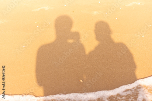 Shadow of couple on sandy beach reflecting connection and romantic travel concept