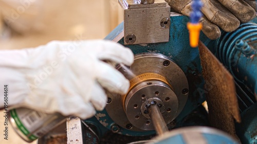 Billede på lærred Worker lubricating machine part for industrial maintenance