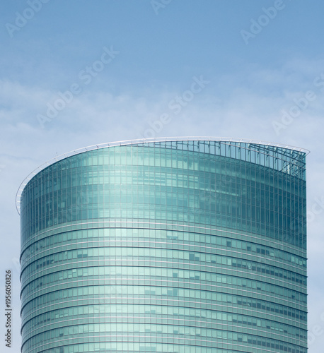 Modern glass skyscraper against blue sky.