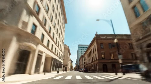 Urban street scene with buildings and cars under a clear sky