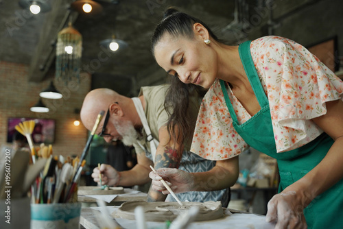 A happy couple makes ceramic plates in a workshop