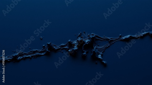 A deep blue background features an irregular black substance with a rough porous surface, splattering tiny particles, re