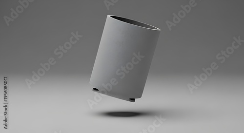 A minimalist studio shot of a grey cylindrical container hovering against a plain neutral background. koozie mockup