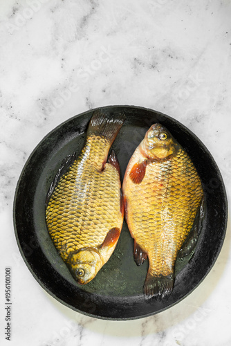 The fish are golden with distinct scales and fins, ready for cooking