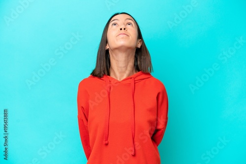 Young caucasian woman isolated on blue background pointing up a great idea