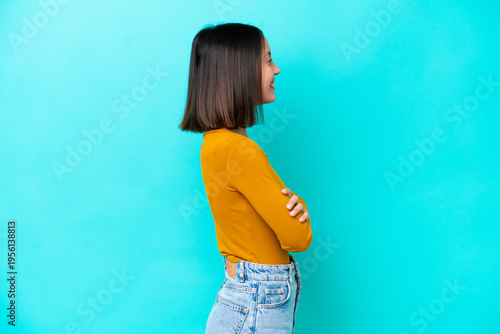 Young caucasian woman isolated on blue background shouting and announcing something