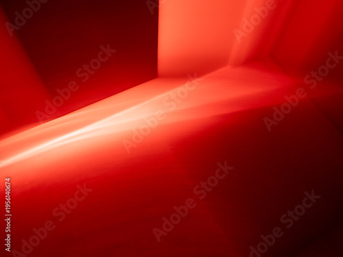Abstract blurred background with intense red light beams and deep shadows, creating a dramatic glowing effect and dynamic texture for creative design projects