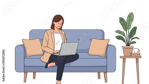 Young woman sitting comfortably on a blue sofa while working on her laptop in a cozy living room with a houseplant nearby.