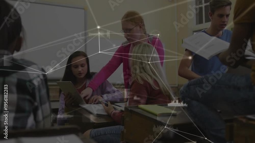 Student in pink leaning and pointing at tablet, peers examining notes, network HUD aiding education