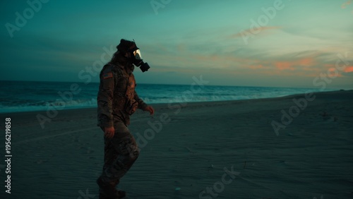 Foto Soldier walks on beach contaminated by radiation from nuclear attack at sunset