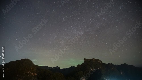 A breathtaking vista showcasing the majestic Milky Way galaxy spanning across a starlit night sky, with silhouettes of rugged mountain peaks in the foreground.