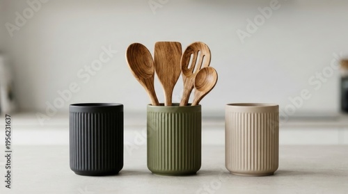 Ceramic utensil holders with wooden spoons, ideal for kitchenware or interior design