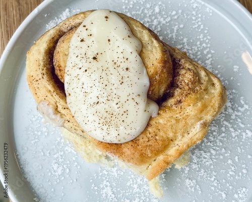 Homemade sweet roll with cinnamon filling and icing, minimal aesthetic food photography.
