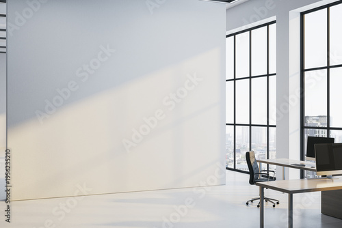 Spacious modern office interior with large blank wall for corporate mockup display and bright window light creating clean contemporary work atmosphere. 3D Rendering