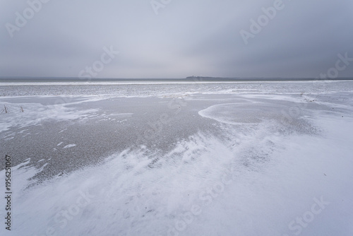 Frozen lake on a cloudy day. Winter landscape.