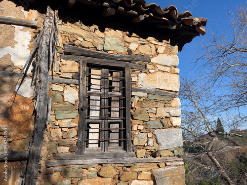 Принти на полотні Close view of rustic stone wall with barred wooden window and terracotta roofline for architectural background and texture design