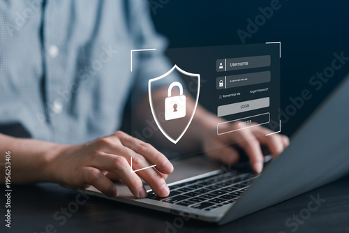 Man hand typing on laptop keyboard with virtual login form and shield padlock icon, representing user authentication, cybersecurity, web data privacy, and secure internet access technology.