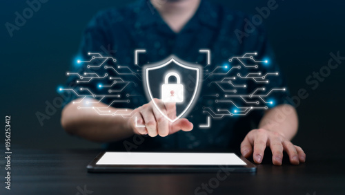 Close up of man hand touching virtual shield padlock icon on tablet with circuit lines, representing cybersecurity, data privacy, cloud computing security, and advanced network protection.
