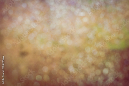 Abstract blurred background with warm golden bokeh lights and soft glowing circles. 