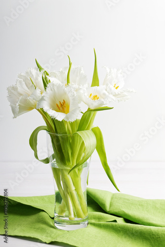 Closeup bouquet of White tulips with fringe in a transparent glass vase