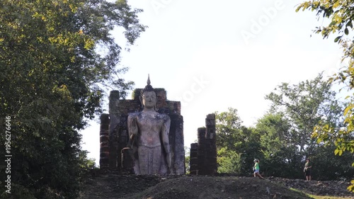 The video's natural background depicts the atmosphere of the ancient Sukhothai Historical Park, an educational site featuring ancient Buddha statues and pagodas.