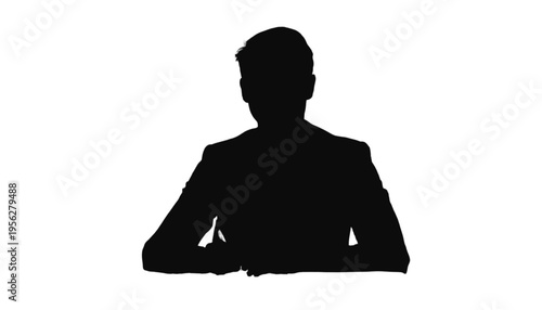 Silhouette of a single businessman wearing a suit jacket sitting at a desk with hands resting on a surface.