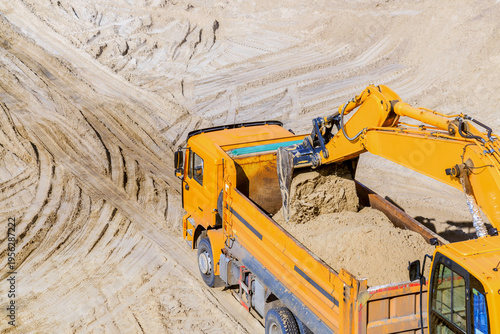Work of the excavator and truck at a sand quarry.