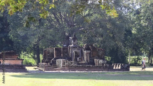 The video's natural background depicts the atmosphere of the ancient Sukhothai Historical Park, an educational site featuring ancient Buddha statues and pagodas.