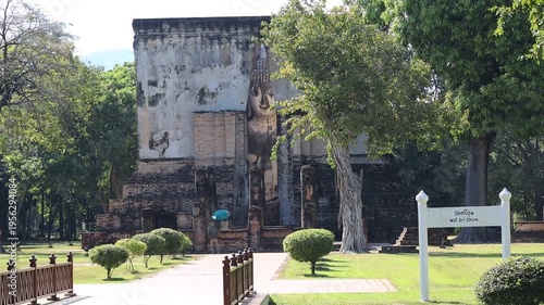 The video's natural background depicts the atmosphere of the ancient Sukhothai Historical Park, an educational site featuring ancient Buddha statues and pagodas.