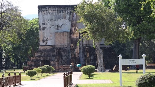 The video's natural background depicts the atmosphere of the ancient Sukhothai Historical Park, an educational site featuring ancient Buddha statues and pagodas.