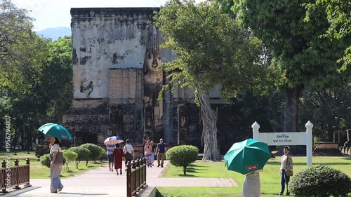 The video's natural background depicts the atmosphere of the ancient Sukhothai Historical Park, an educational site featuring ancient Buddha statues and pagodas.