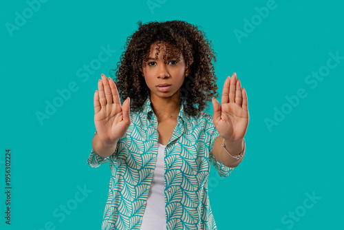 Serious african woman with open palm in stop gesture, assertive body language