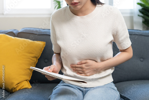Menstruation, periods cycle day of monthly, hurt young woman, girl stomachache, hand holding marking symbol on calendar for missed and delay or late at home. Medical, healthcare, gynecological concept