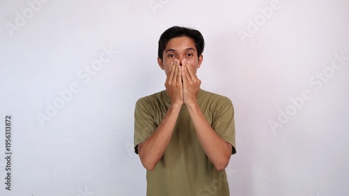 handsome asian young man surprised gesture covering mouth using both hands with isolated white background